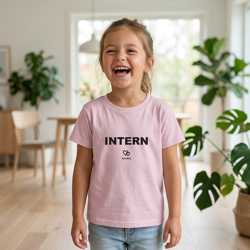 Laughing girl in a pink Bondkin Intern tee in a bright living room