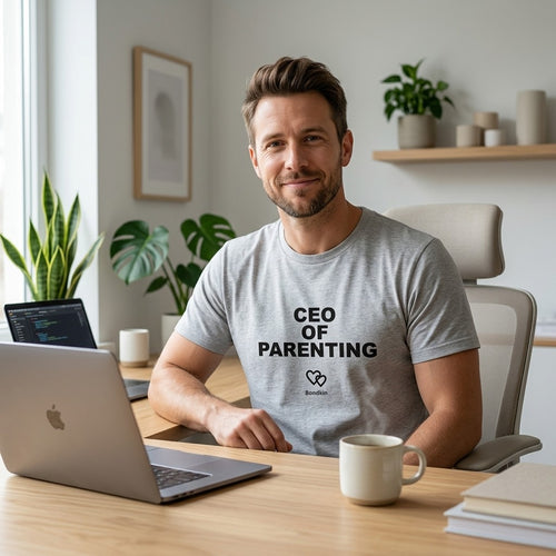 Man in a grey Bondkin CEO of Parenting tee at a home office desk