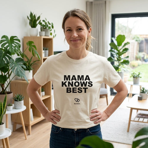 Smiling woman in a cream Bondkin Mama Knows Best tee, hands on hips