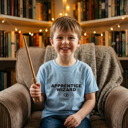Boy in a blue Bondkin Apprentice Wizard tee holding a toy wand